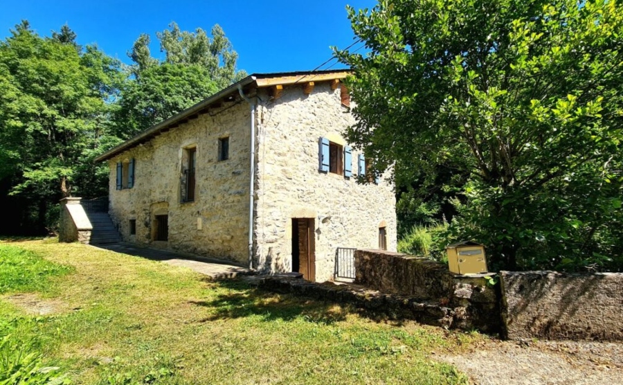 Typical stone farmhouse in the French countryside with blue shutters and stone walls