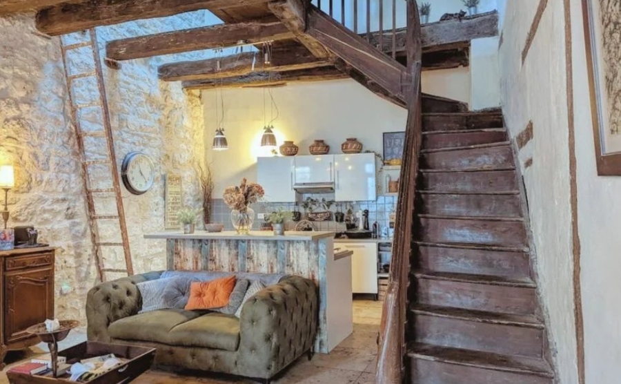 Interior of a traditional farmhouse in France with wooden furnishings and a plush, Chesterfield sofa